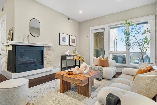 a living room with furniture a large window and a fireplace