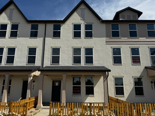 1876 West 1575th North, Unit 237 Layton, UT 84041 - Photo 1 of 20 Modern townhome featuring a neutral stucco exterior, dark roofline, and multiple vertical windows