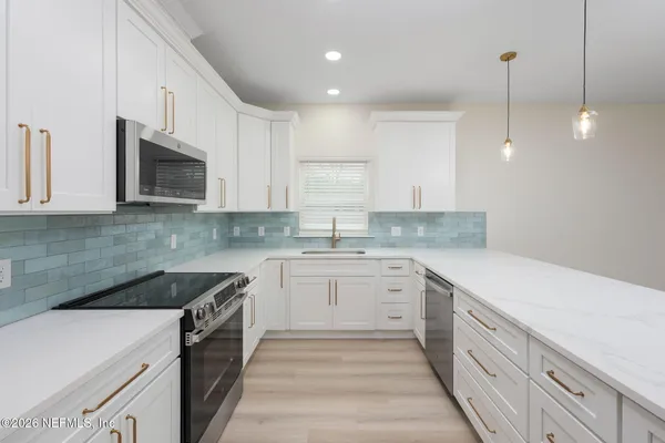 a kitchen that has a sink and a stove in it