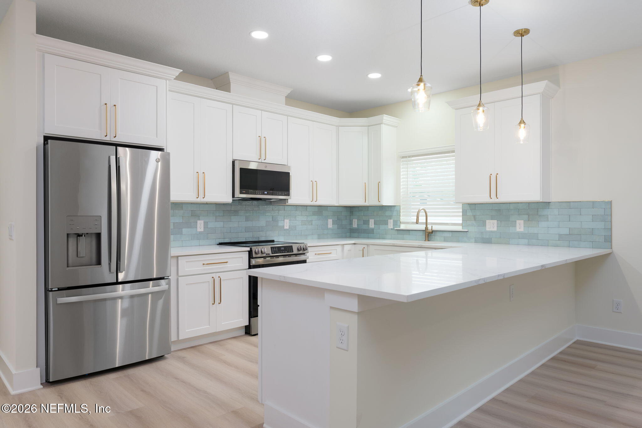 688 Madeore Street St. Augustine, FL 32084 - Photo 9 of 28 a kitchen with stainless steel appliances granite countertop a refrigerator a sink a stove a microwave and wooden floor