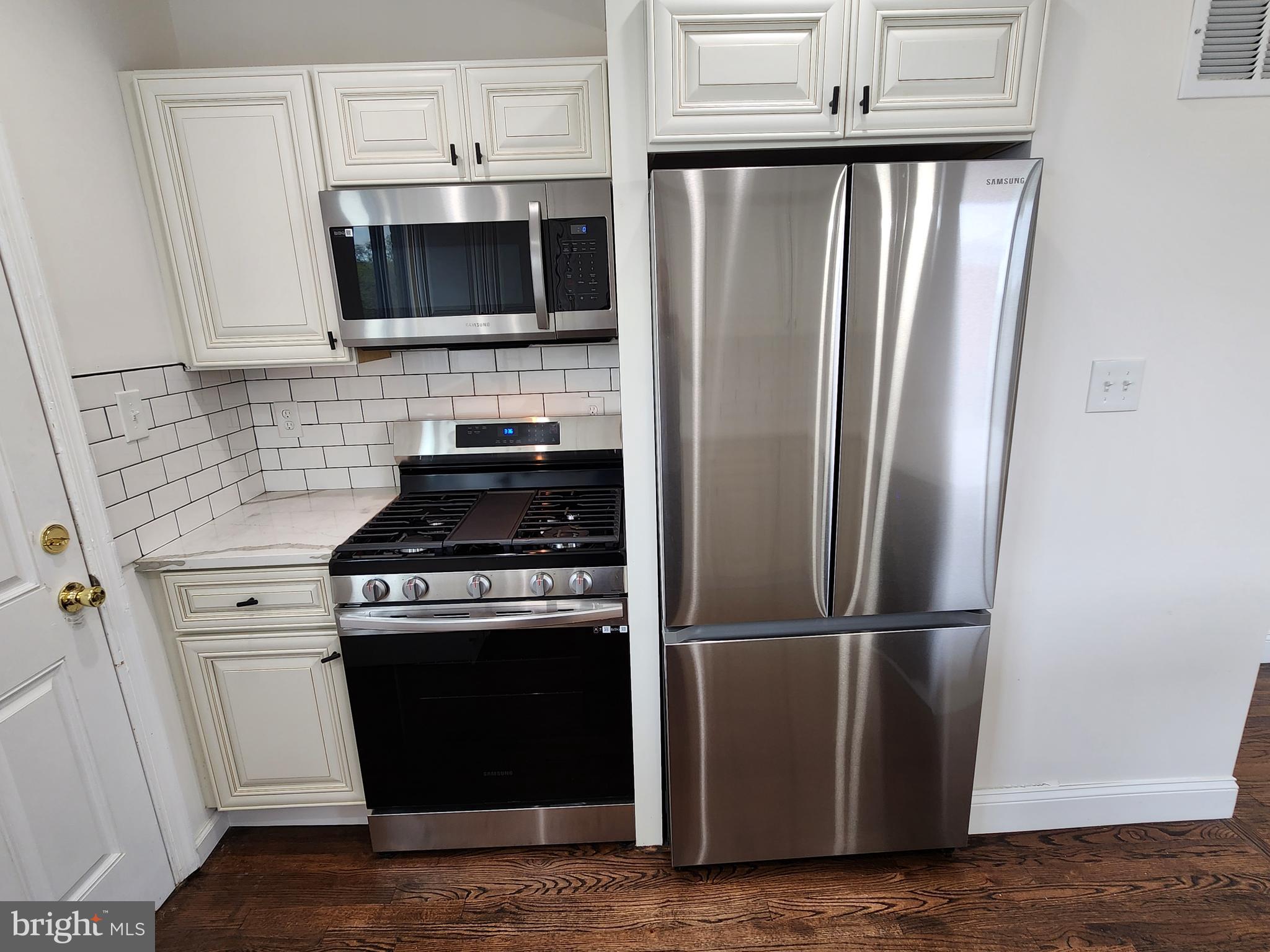 1261 Gallatin Street Northeast Washington, DC 20017 - Photo 15 of 60 a kitchen with granite countertop a stove and a refrigerator