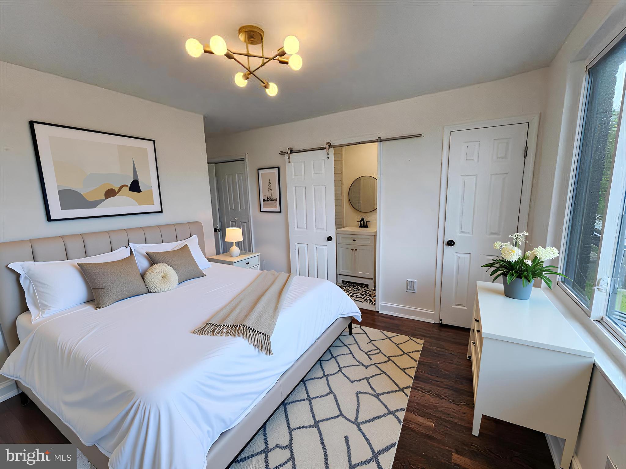 1261 Gallatin Street Northeast Washington, DC 20017 - Photo 18 of 60 a spacious bedroom with a bed and a chandelier