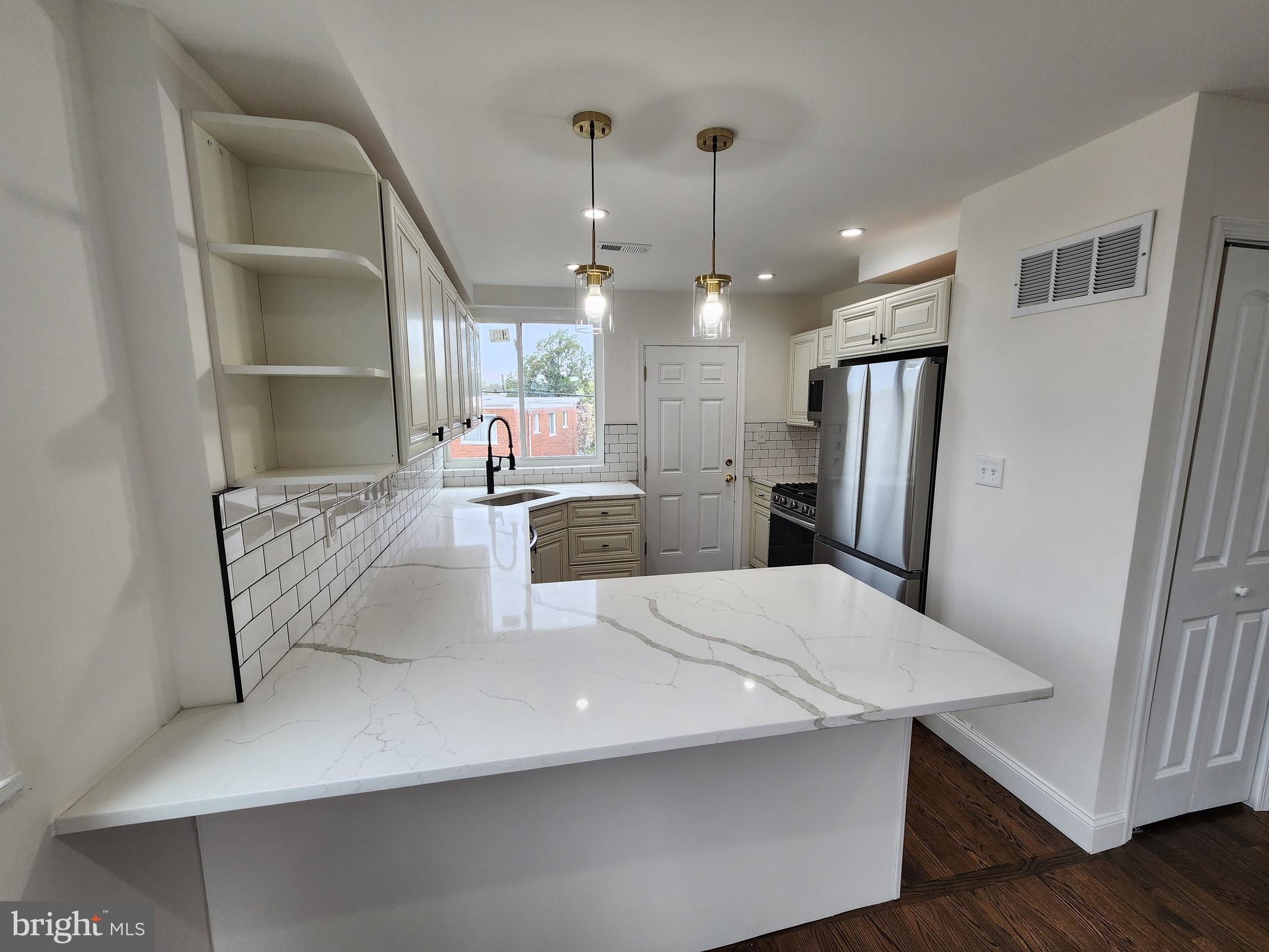 1261 Gallatin Street Northeast Washington, DC 20017 - Photo 9 of 60 a large kitchen with stainless steel appliances a refrigerator a sink dishwasher a dining table and chairs with wooden floor