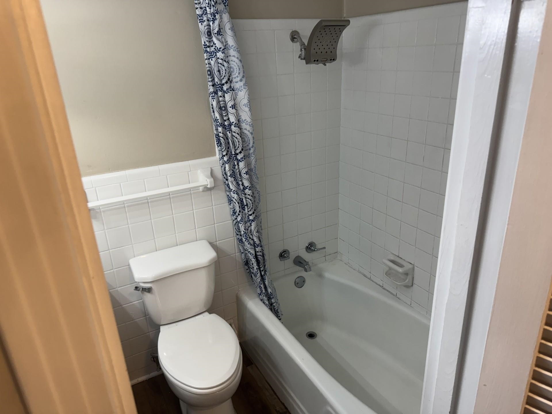 2631 Highway 51 Ripley, TN 38063 - Photo 12 of 17 Bathroom with shower / bath combo with shower curtain, tile walls, and wainscoting