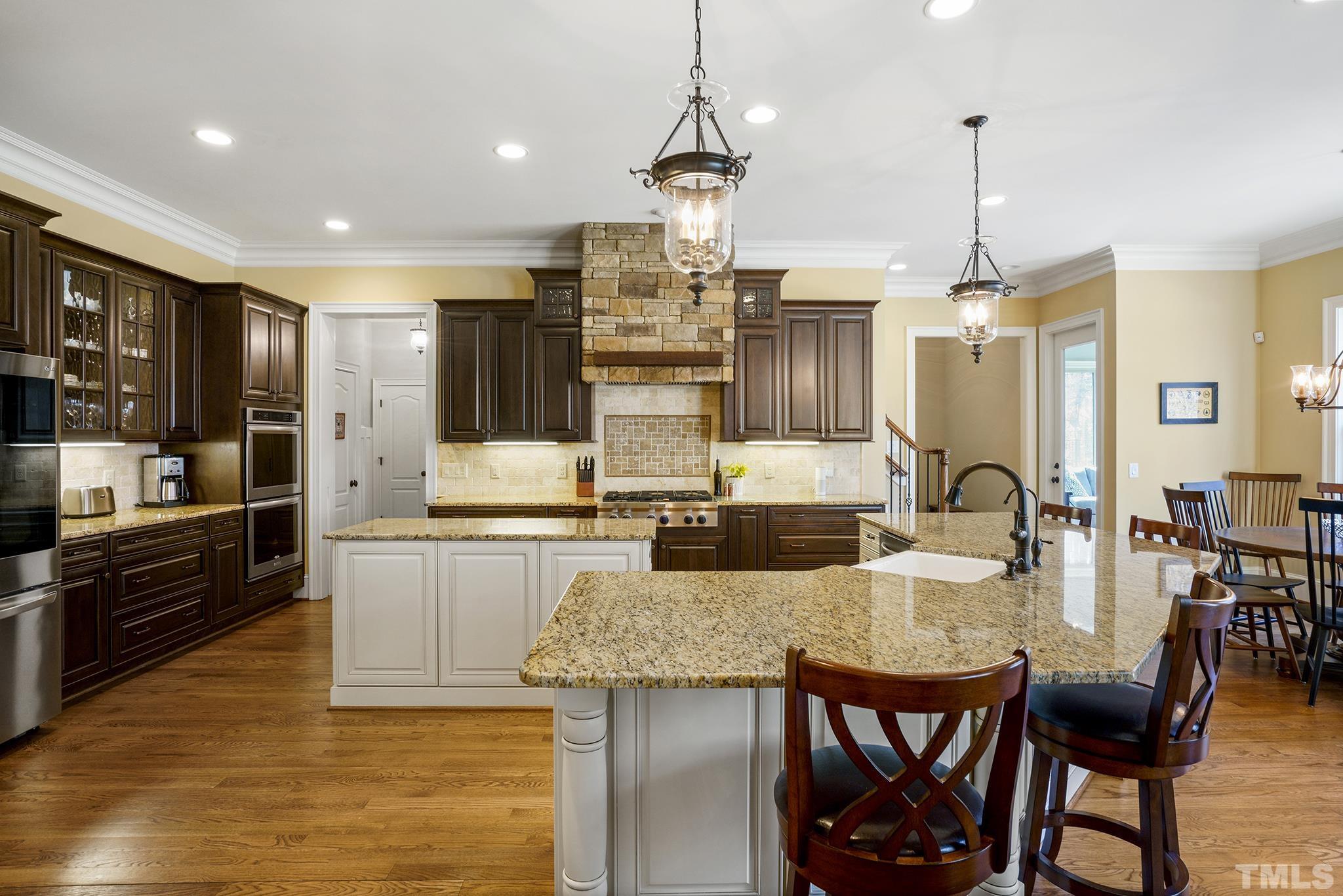 6837 Mactavish Way Raleigh, NC 27613 - Photo 17 of 48 a kitchen with granite countertop kitchen island stainless steel appliances a table and chairs