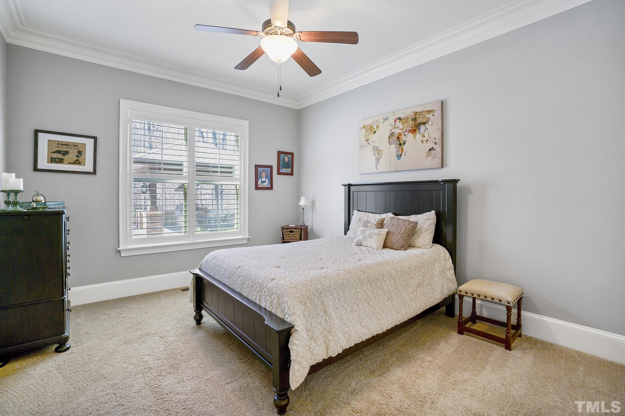 6837 Mactavish Way Raleigh, NC 27613 - Photo 21 of 48 a spacious bedroom with a bed and a chandelier