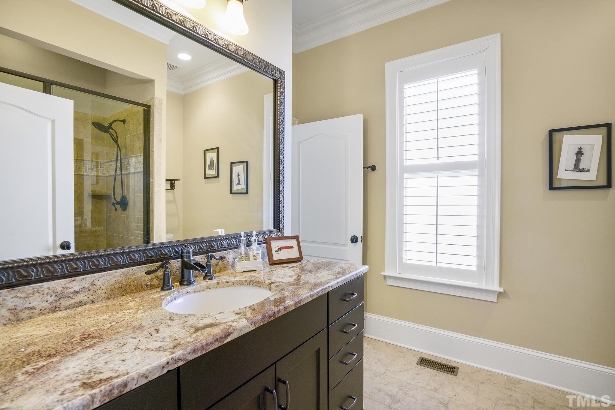 6837 Mactavish Way Raleigh, NC 27613 - Photo 22 of 48 a bathroom with a granite countertop sink and a mirror