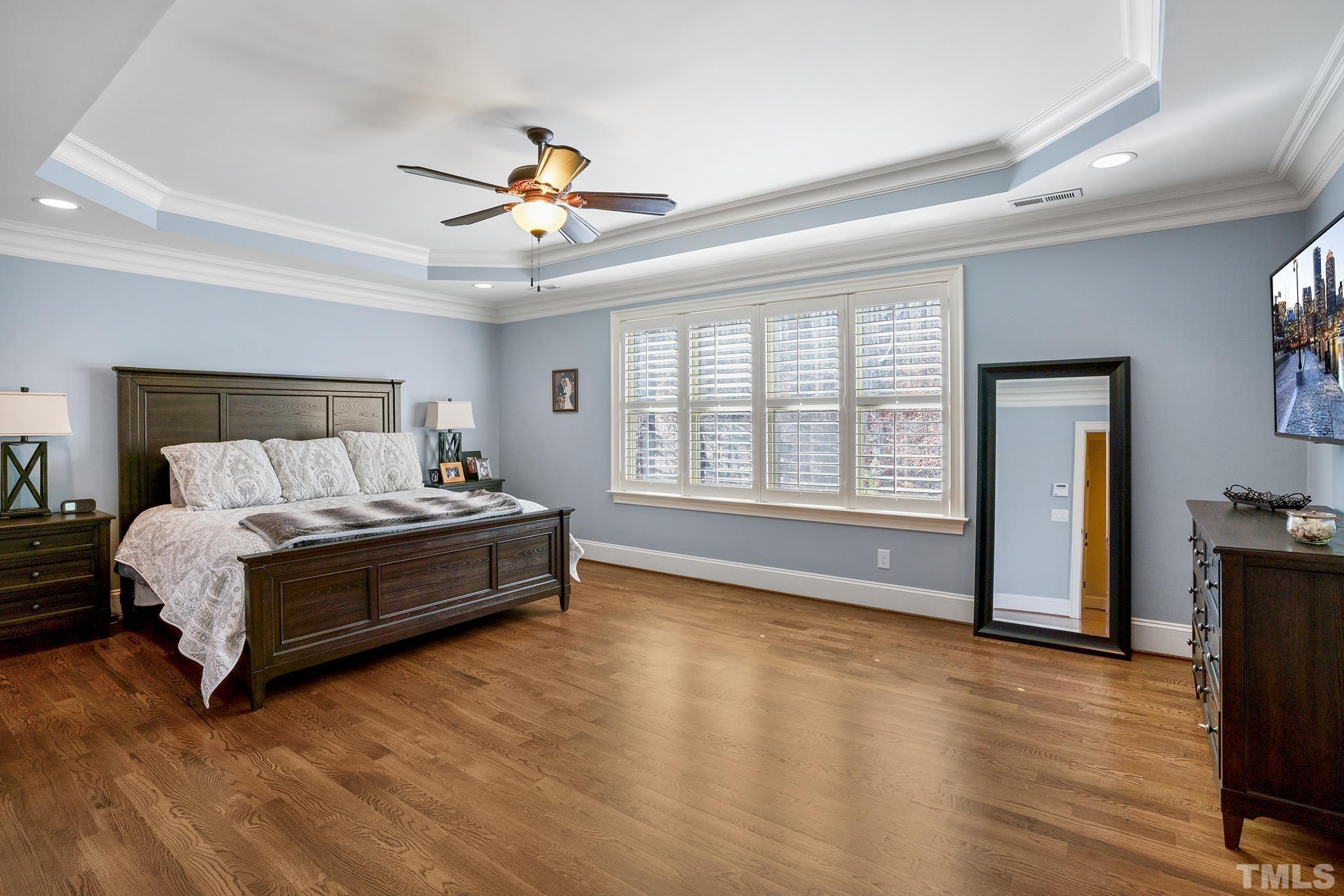 6837 Mactavish Way Raleigh, NC 27613 - Photo 24 of 48 a spacious bedroom with a bed and wooden floor