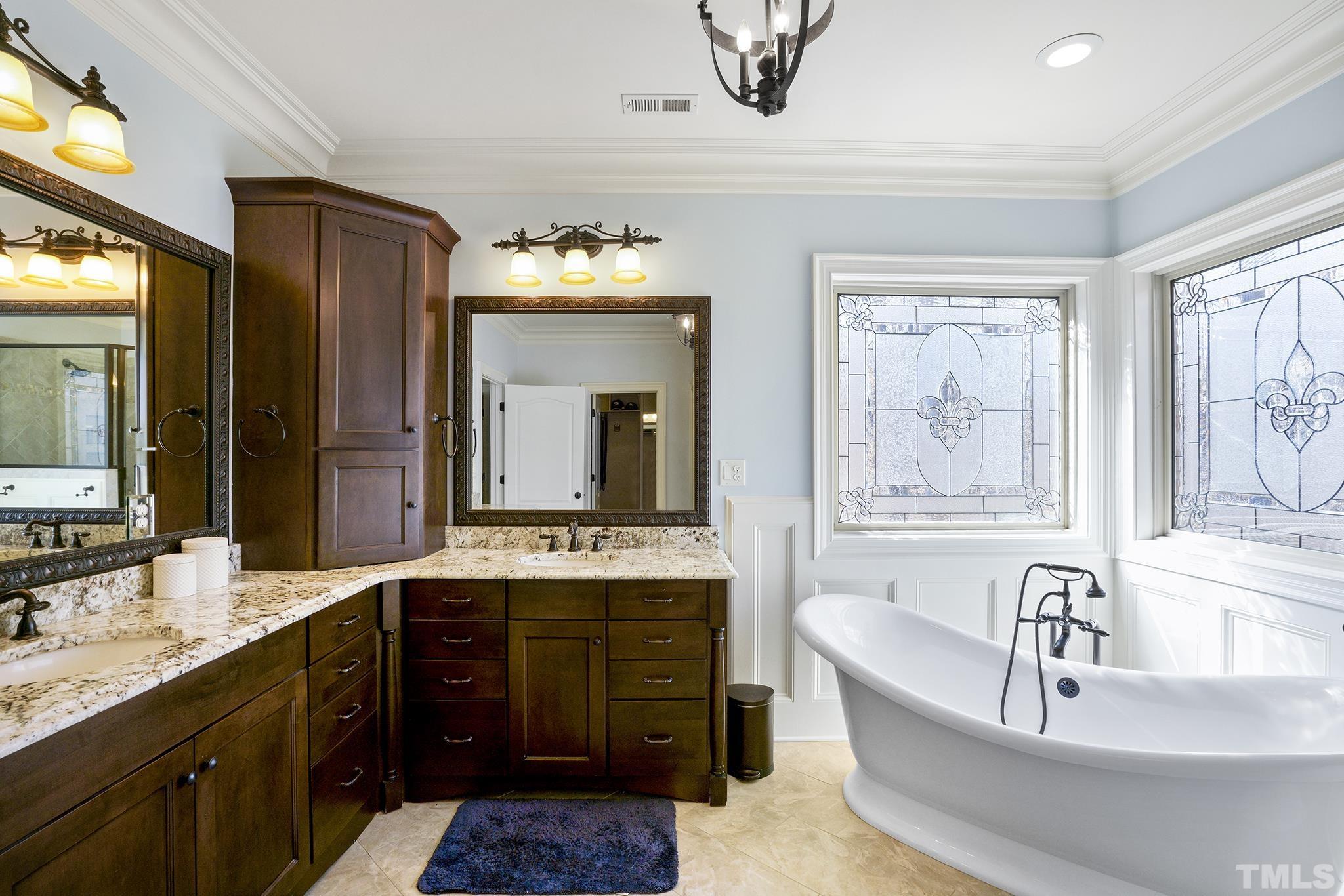 6837 Mactavish Way Raleigh, NC 27613 - Photo 27 of 48 a spacious bathroom with a granite countertop tub sink and mirror