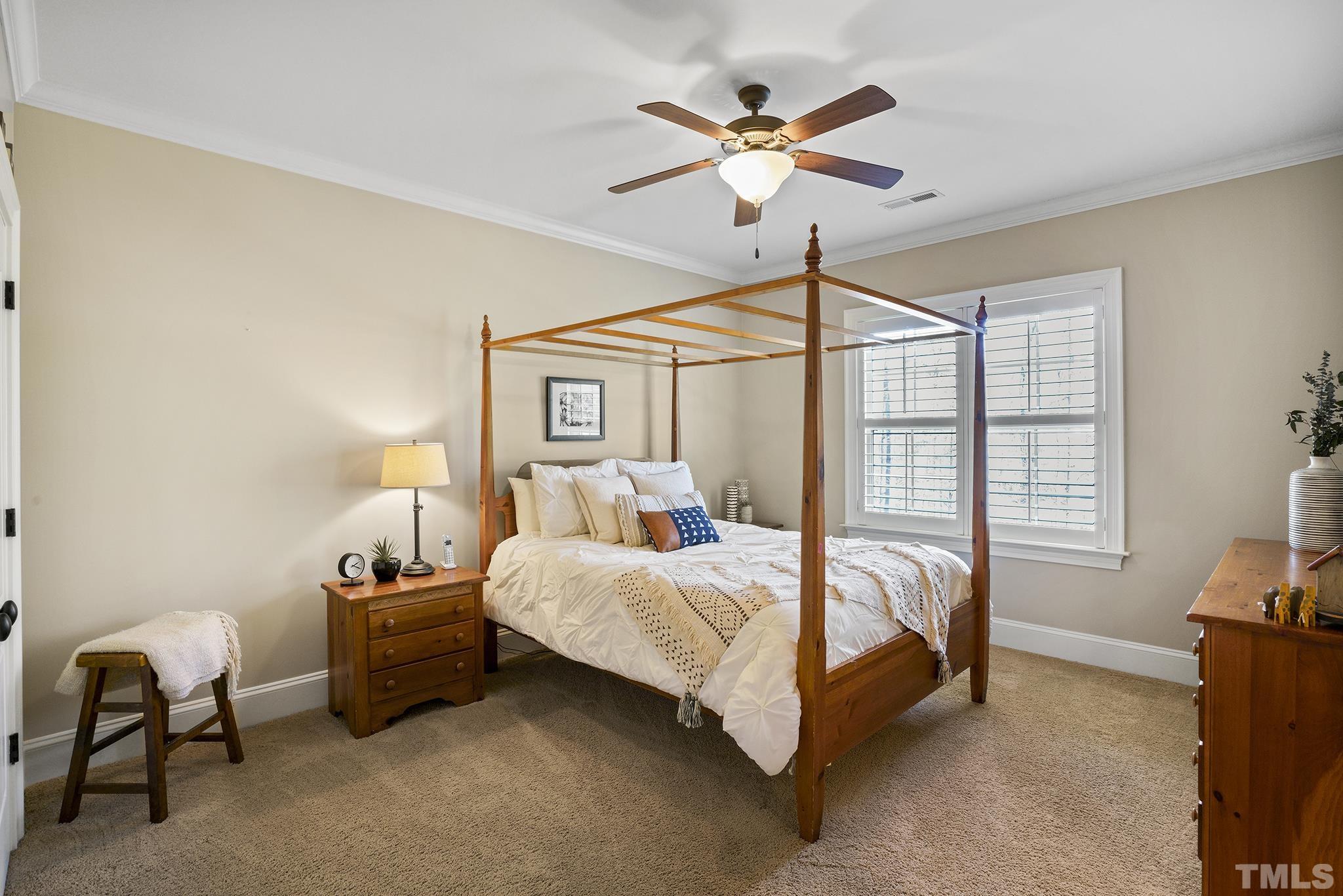 6837 Mactavish Way Raleigh, NC 27613 - Photo 28 of 48 a bedroom with a bed a chandelier and a chair