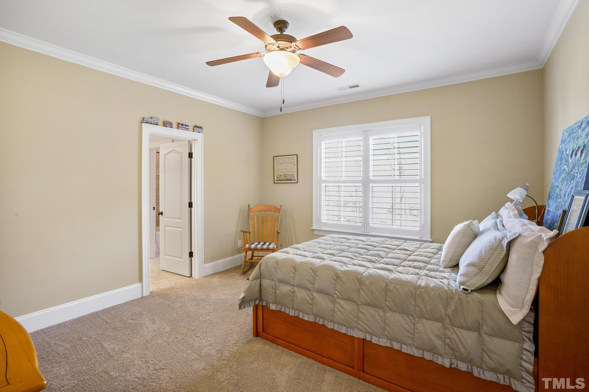 6837 Mactavish Way Raleigh, NC 27613 - Photo 30 of 48 a bedroom with a bed and a chandelier