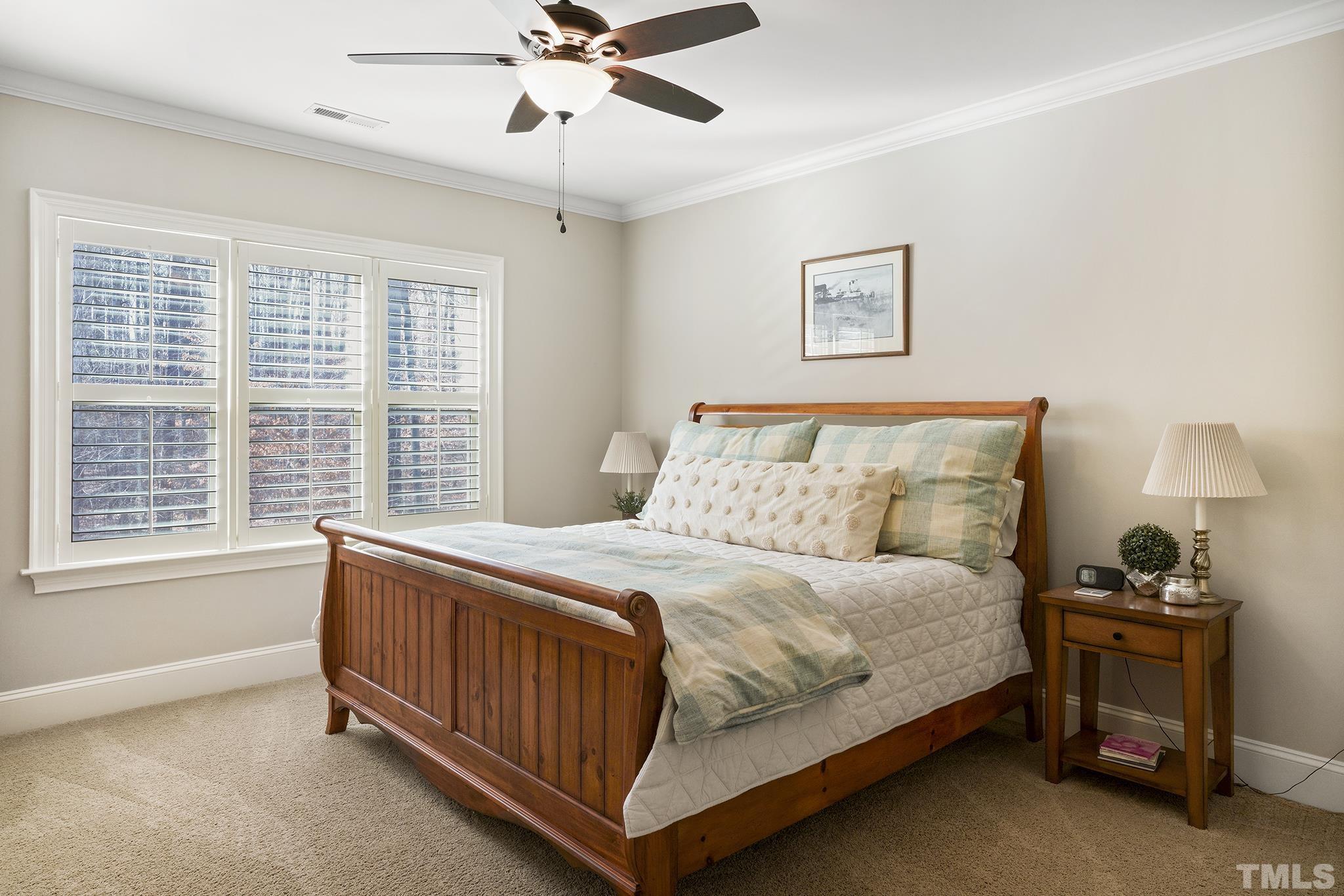 6837 Mactavish Way Raleigh, NC 27613 - Photo 31 of 48 a bedroom with a bed and a chandelier