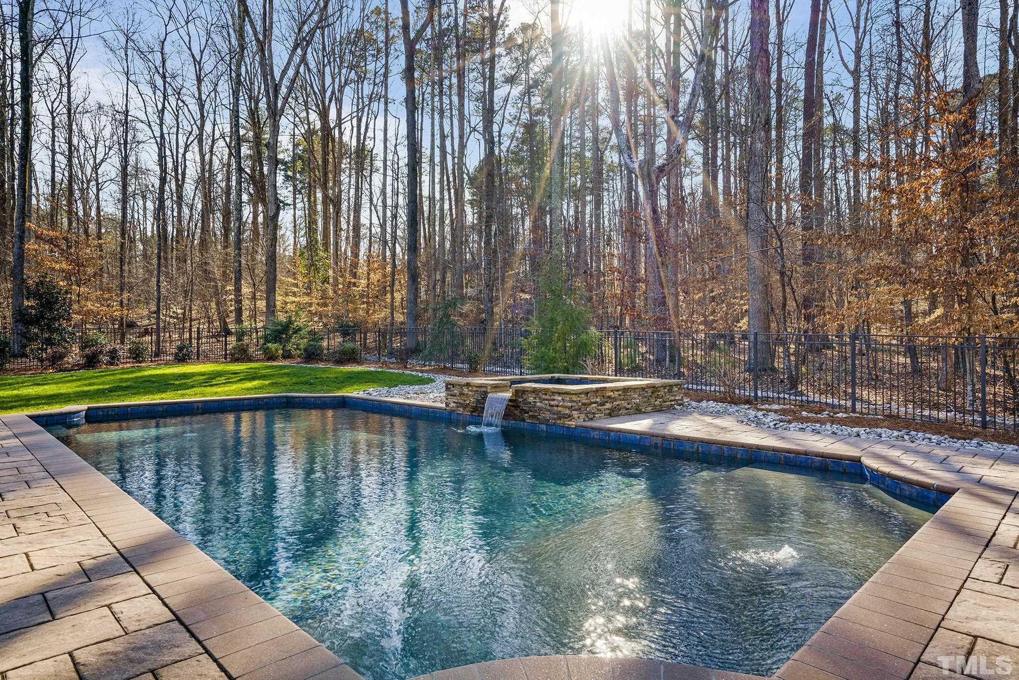6837 Mactavish Way Raleigh, NC 27613 - Photo 44 of 48 a swimming pool with plants and trees in the background