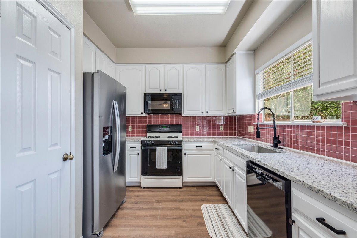 9300 Tea Rose Trail Austin, TX 78748 - Photo 11 of 33 A galley-style kitchen with sleek appliances and abundant white cabinetry awaits culinary endeavors.