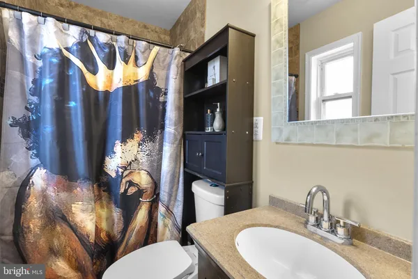 a bathroom with a toilet sink and mirror