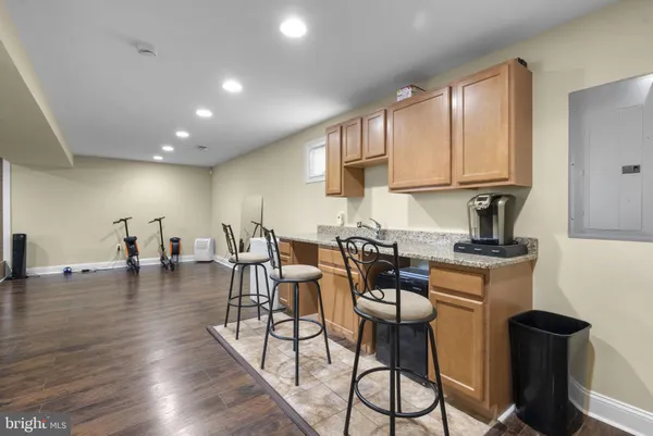 a kitchen with stainless steel appliances granite countertop a stove top oven a dining table and chairs with wooden floor