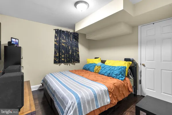 a bedroom with a bed and a lamp on the dresser