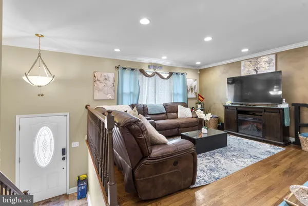 a living room with furniture a flat screen tv and kitchen view