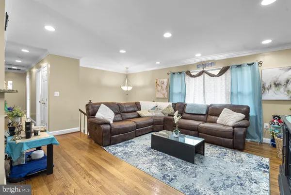a living room with furniture a rug kitchen view and a chandelier