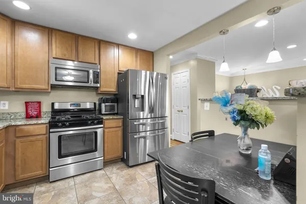 a kitchen with stainless steel appliances granite countertop a stove refrigerator and microwave