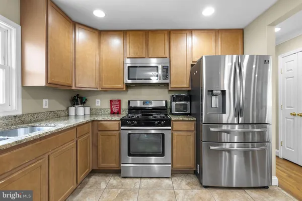 a kitchen with stainless steel appliances granite countertop a refrigerator stove and sink