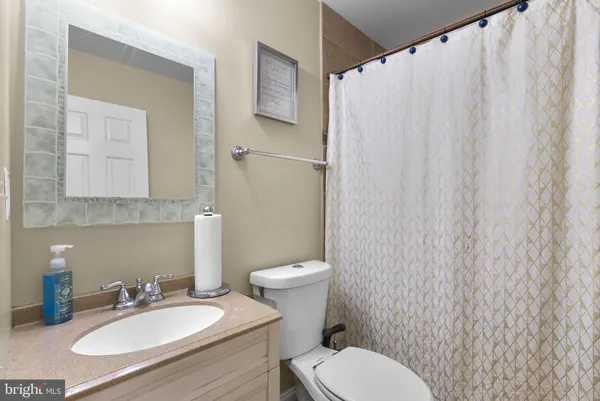 a bathroom with a sink a toilet and a mirror