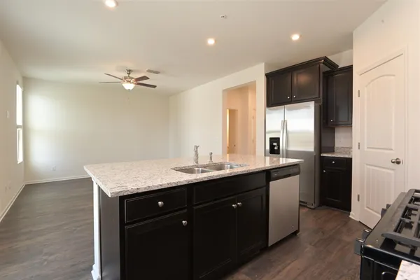 a kitchen with a sink a refrigerator and stove