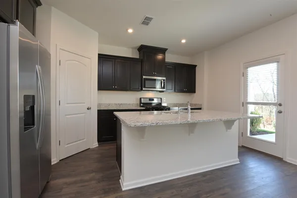 a kitchen with stainless steel appliances granite countertop a sink stove and refrigerator
