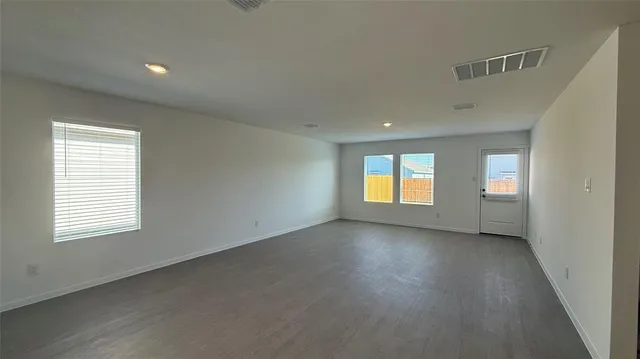 an empty room with a window and doors
