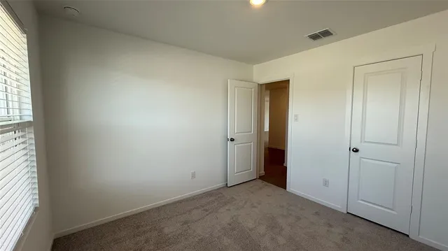 an empty room with windows and closet