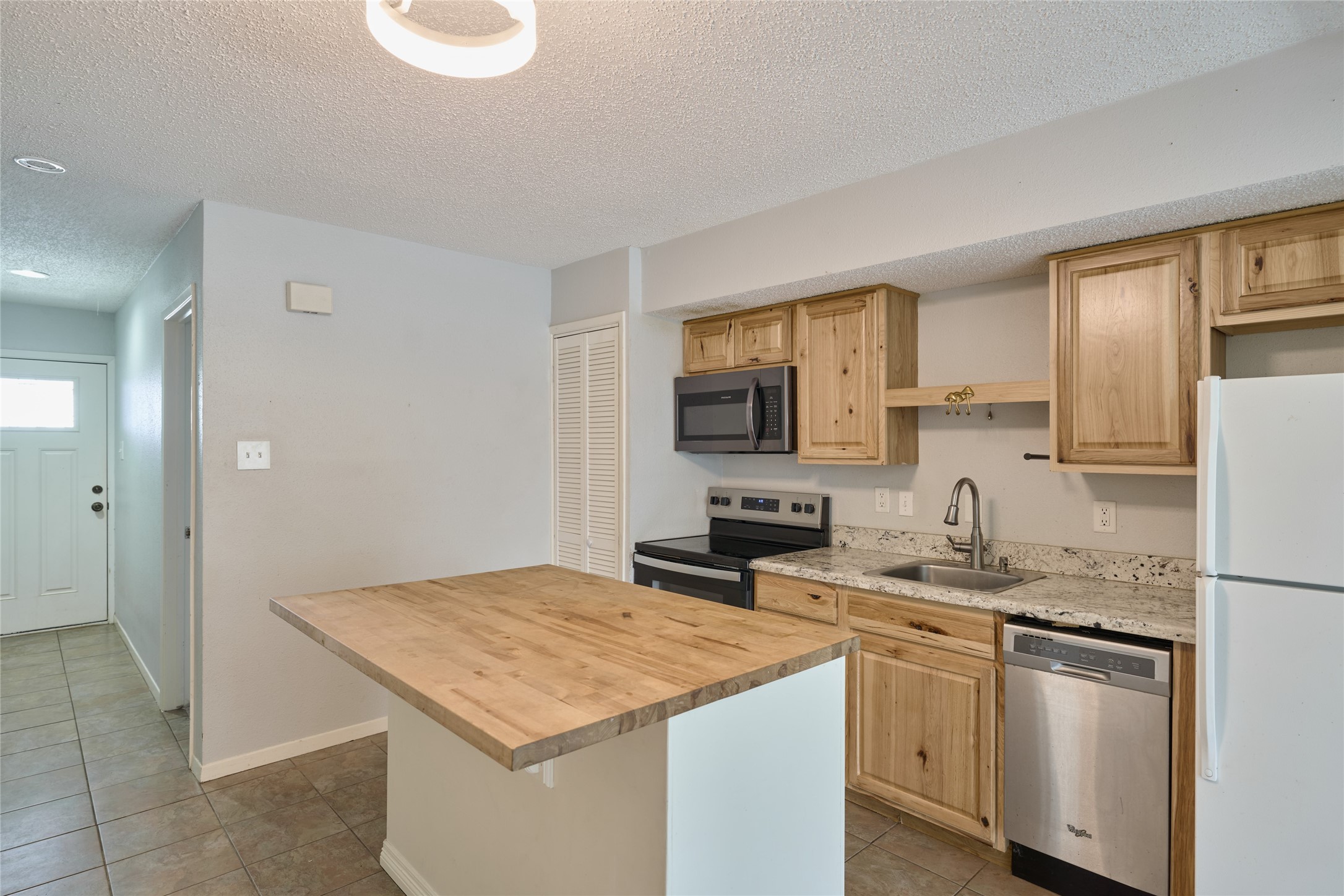 12900 Walden Road, Unit 622F Montgomery, TX 77356 - Photo 6 of 32 a kitchen with granite countertop a sink stove and refrigerator