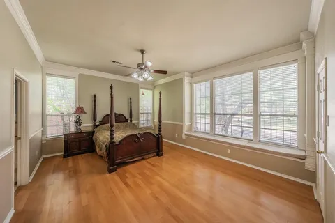 a spacious bedroom with a bed and glass window