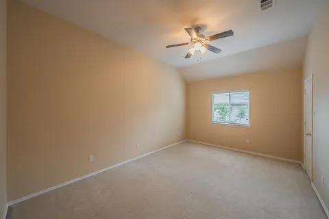 an empty room with a window and a fan