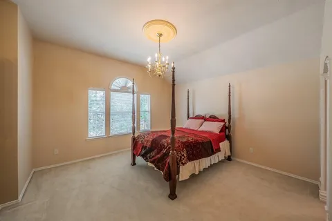 a bed sitting in a spacious bedroom next to a window