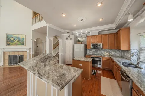 a kitchen with stainless steel appliances granite countertop a sink refrigerator stove and microwave