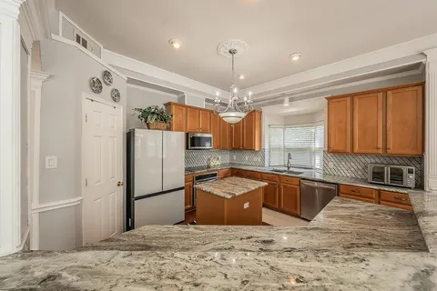 a kitchen with granite countertop a refrigerator and a sink
