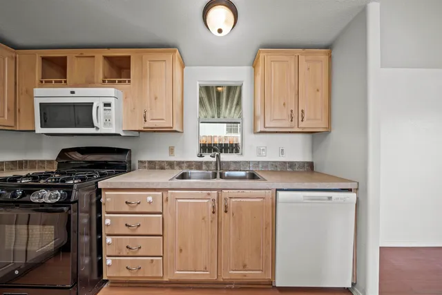 a kitchen with cabinets appliances a sink and a window