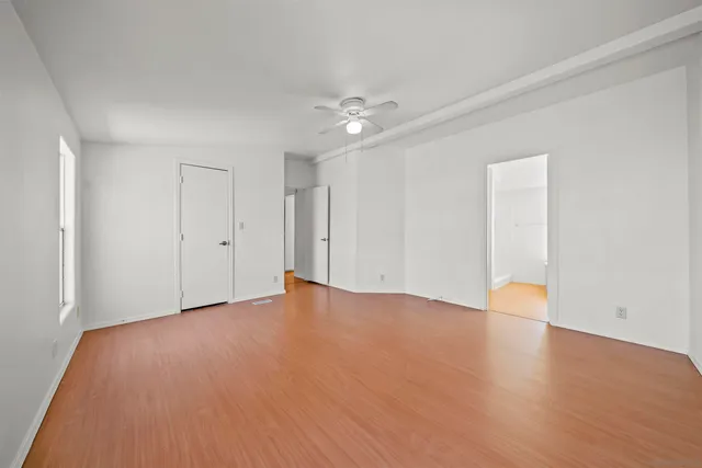 a view of an empty room with wooden floor