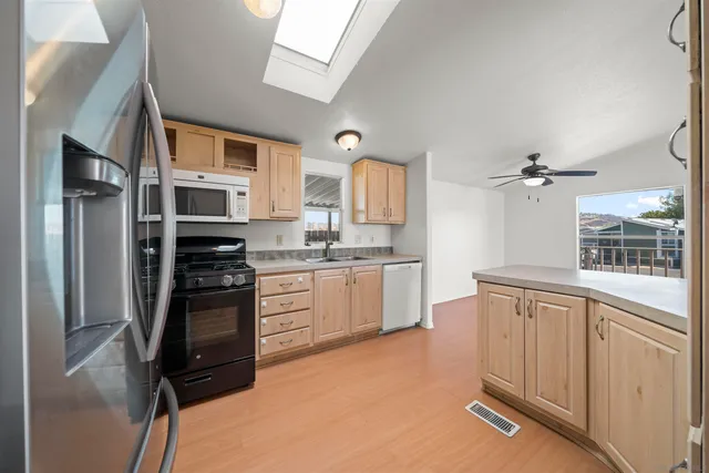 a kitchen with stainless steel appliances granite countertop a refrigerator sink and stove