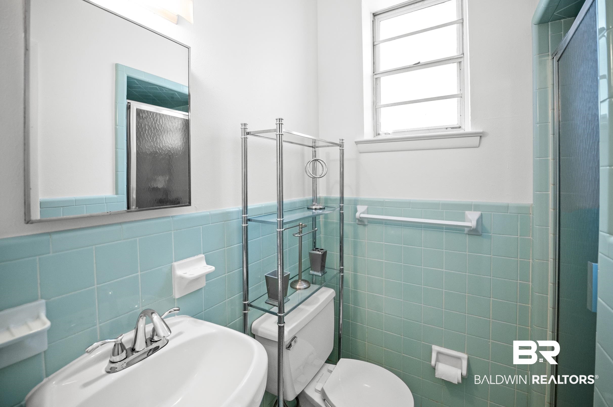 9459 Soldier Creek Road Lillian, AL 36549 - Photo 38 of 54 Full bath with tile walls, toilet, a stall shower, wainscoting, and a sink