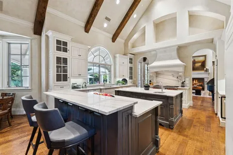 a kitchen with a stove a sink dishwasher and a dining table with chairs