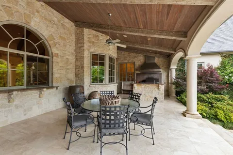 a patio with table and chairs and potted plants