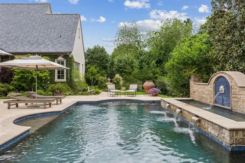a view of a house with pool and chairs