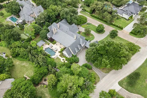 an aerial view of residential house with outdoor space and a lake view in back