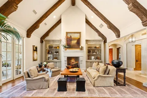 a living room with furniture fireplace and a large window