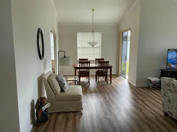 a dining room with furniture a chandelier and wooden floor