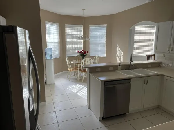 a kitchen with stainless steel appliances granite countertop a sink and a refrigerator