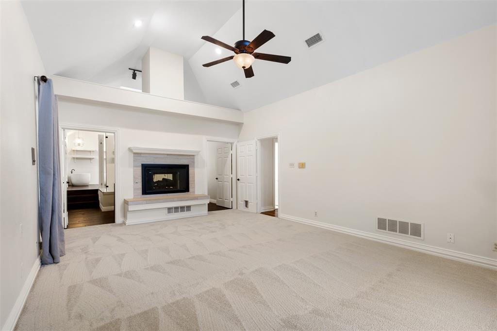 609 Seville Road Denton, TX 76205 - Photo 22 of 40 Primary bedroom with carpet, ceiling fan, dual-sided fireplace with gas logs and en-suite bathroom.