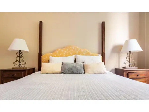 a bedroom with a bed and a lamp