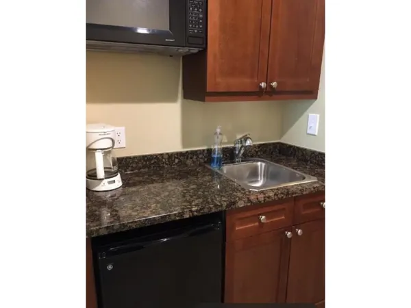 a kitchen with granite countertop a sink and cabinets